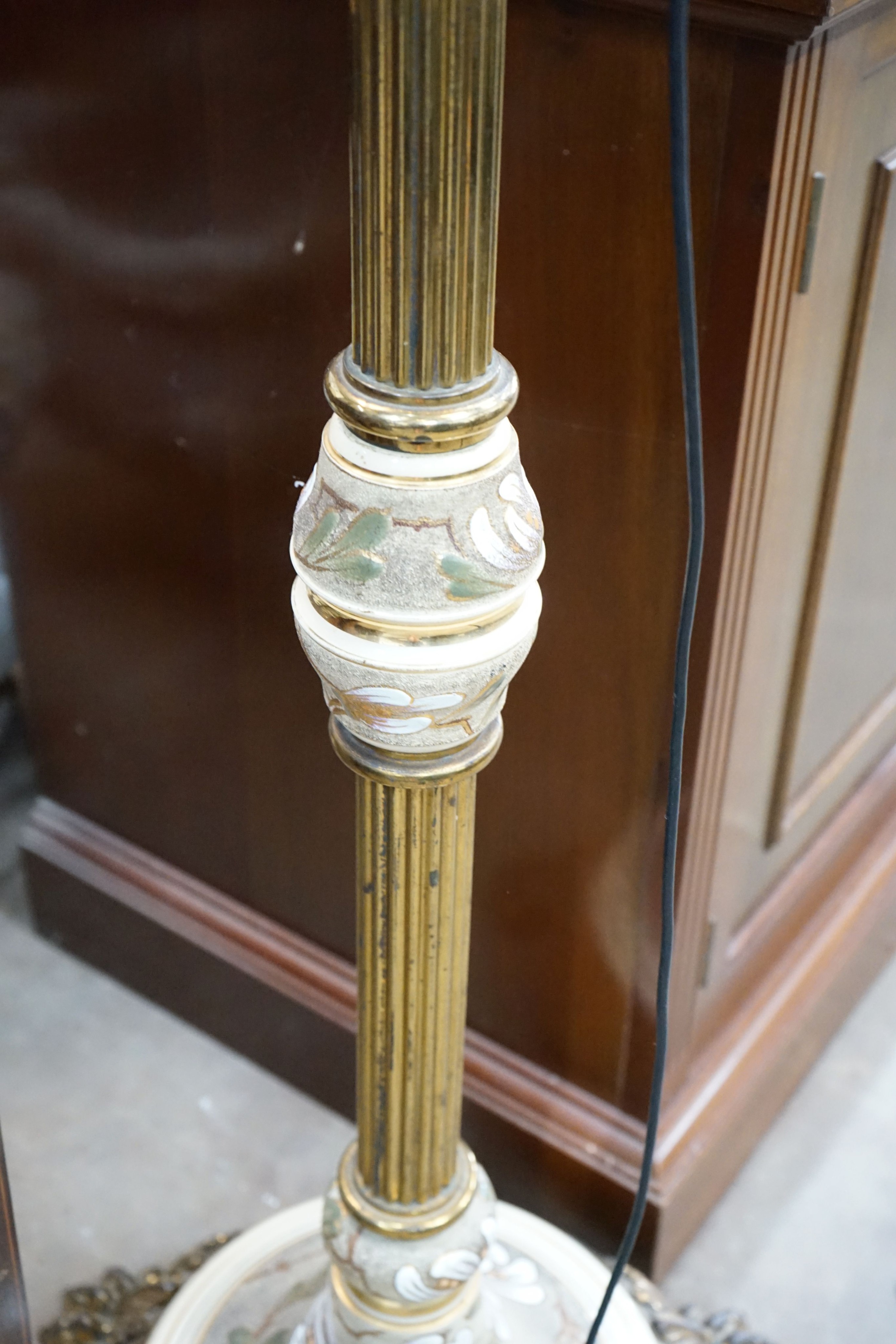 A brass and ceramic standard lamp on lion's paw feet, height 160cm